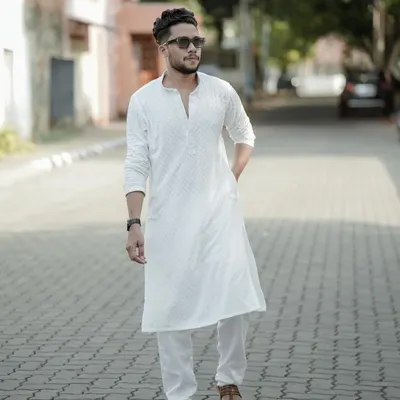 A classic men's fashion portrait. The subject's confident walk down a quiet street, dressed in a crisp white kurta, creates a timeless and stylish look.