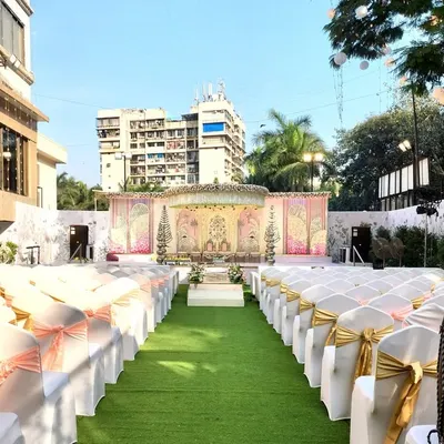 This image shows how I can transform an outdoor space at Siddharth Banquets for a beautiful daytime wedding. The open-air setting allows for a grand mandap setup with clear views, and the guest seating is arranged along a green turf aisle for a garden ceremony feel.