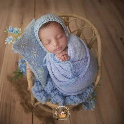 A perfect little bundle in blue. I use soft, textured wraps and a matching bonnet to create a cozy and coordinated look, highlighting the peaceful sleep of a newborn.