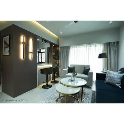 A wide view of the transformed Tulsi Heights living room, showing the open layout with the breakfast bar, modern furniture, and layered lighting that creates a warm, inviting ambiance.