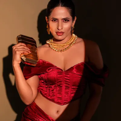 This shot is all about glamour and confidence. I used dramatic spotlighting to create a high-contrast look that emphasizes the rich red of the outfit and the bold gold jewelry.