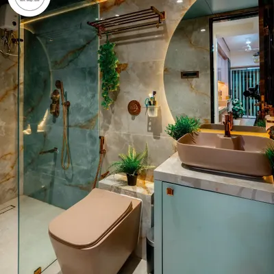 A luxurious bathroom featuring green onyx-style tiles and brushed copper fittings. The large, backlit round mirror and mint-colored vanity with a vessel sink create a stunning focal point.