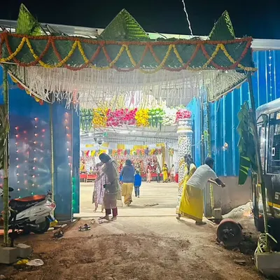 A traditional 'chapra' or woven leaf canopy, decorated with marigold garlands, set up at the entrance for a temple festival, creating a rustic and authentic welcome.