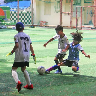 A player makes a decisive slide tackle during a competitive match, showcasing the courage and timing we instill in our defenders.