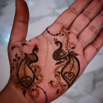 A simple yet charming example of my minimalist henna art. This design features two small, elegant peacocks on the palm, connected by a delicate beaded chain, perfect for someone who wants a touch of tradition without full coverage.