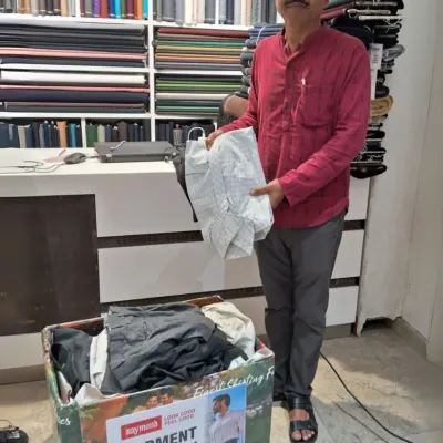 Give your old clothes a second life. A happy contributor at our Garment Drop Box, turning compassion into action.