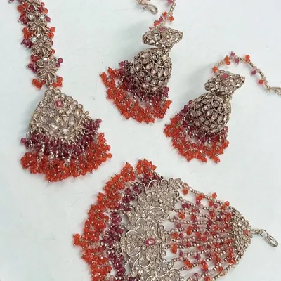 A beautiful rental set from my Mehendi and Haldi collection. This set features a maang tikka, hathphool, and jhumka earrings with red and orange beads.