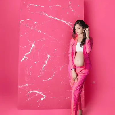 A bold and modern maternity look! This mom-to-be is absolutely glowing in a hot pink pantsuit, proving that pregnancy style can be fun, fashionable, and powerful.