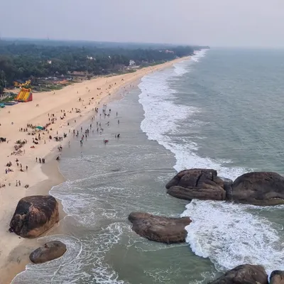 An aerial view of the stunning coastline at Kapu Beach near Udupi. The vast expanse of sand, sea, and the distant lighthouse makes for a breathtaking sight.