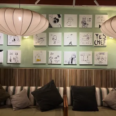 A full view of the gallery wall I created for Sidewalk Cafe in Kanpur. This set of 24 custom doodle-style paintings adds a fun and quirky character to the space.