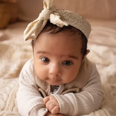 Just the baby. A simple, close-up portrait of a beautiful newborn with the most soulful eyes, captured on a soft, textured blanket.