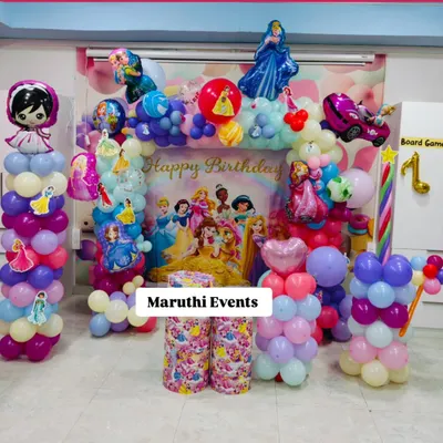 A grand Disney Princess birthday celebration. This setup features a beautiful backdrop with all the iconic princesses, surrounded by a pastel balloon arch and character balloon sculptures.