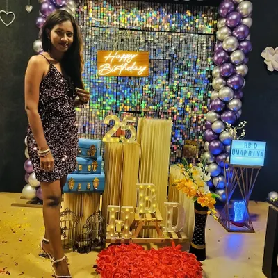 Turning 25 in style. This picture captures our popular purple and silver decor theme, complete with a neon 'Happy Birthday' sign, a heart made of roses, and personalized light-up letters.