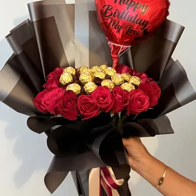 Making birthdays more special with this stunning hand-held bouquet. It features deep red roses and Ferrero Rocher chocolates, wrapped in sophisticated black and grey paper and topped with a "Happy Birthday My Love" balloon.