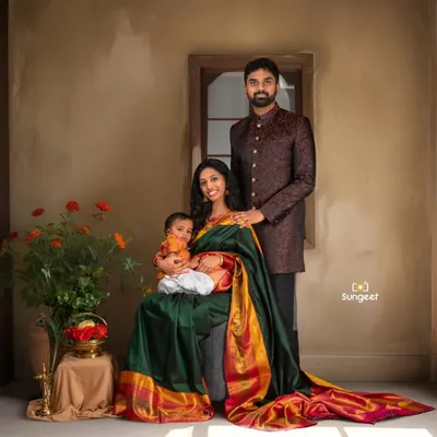 A beautiful family portrait celebrating their second journey to parenthood. The mother, dressed in a traditional silk saree, holds her toddler, creating a warm and complete picture of their growing family.