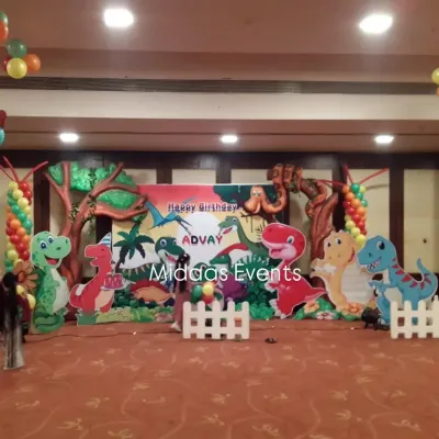 This is the main stage for Advay's dinosaur-themed party. I used a combination of a printed backdrop, large friendly dinosaur cutouts, and tree props to create a complete prehistoric scene for the cake-cutting ceremony.