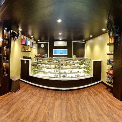 A panoramic view of my bakery. My display counter is always filled with a wide selection of fresh cakes, pastries, and party supplies for your celebrations.