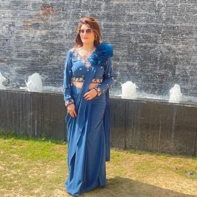 I'm wearing one of my favorite creations, a blue pre-stitched drape saree. It has the grace of a saree and the comfort of a gown, with a beautifully embroidered blouse and a 3D floral detail.