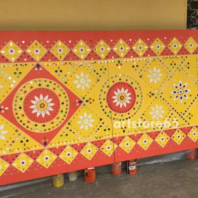 A finished Lippan wall panel featuring traditional geometric and floral patterns from Kutch. The bright yellow and red color scheme is classic, making it a vibrant addition to any interior design seeking an ethnic touch.