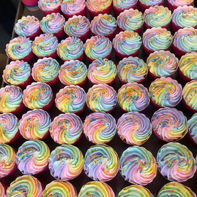 A full tray of our rainbow cupcakes ready for a corporate event. The swirl of pastel colors makes for a beautiful and delicious display.