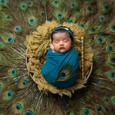 A classic Krishna-themed portrait, with your newborn swaddled peacefully against a backdrop of magnificent peacock feathers. I use a tiny flute prop and a matching headband to complete this divine look.