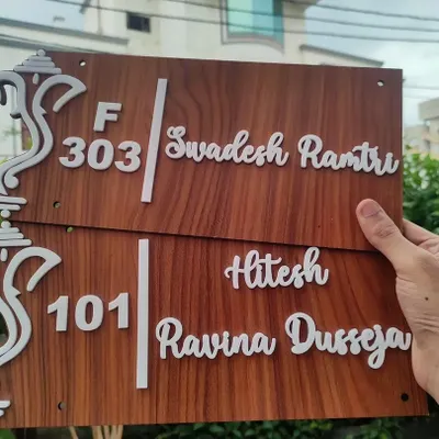 A pair of custom wooden door nameplates ready for delivery. I can customize the names, flat numbers, and even the Ganesha design to match your style.