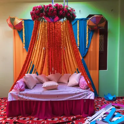 A complete Haldi ceremony seating arrangement I designed. The decor features a mix of traditional marigold garlands and elegant red roses, set against a vibrant fabric backdrop to create a perfect photo corner for the bride or groom.