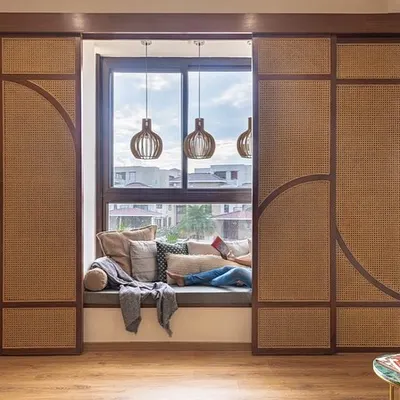 This cozy window seat is framed by custom cane and wood sliding screens. The screens offer the flexibility to create a private, enclosed nook or an open, light-filled space.