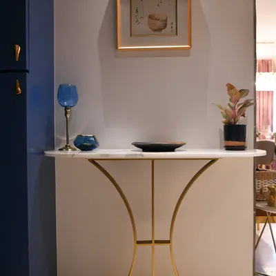 A console table is a statement piece. This design features a marble top and curved gold metal legs, perfect for an entryway. It can be styled with art, greenery, or decor to transform the vibe.