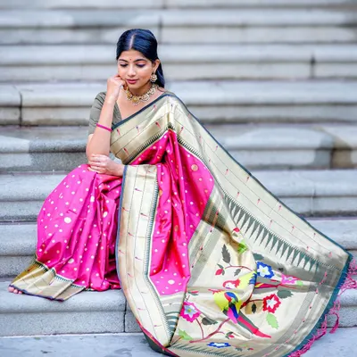 This beautiful pink Paithani semi-soft silk saree features a stunning pallu with colorful parrot motifs. The way it drapes on the steps showcases the richness of the fabric and its intricate weave.