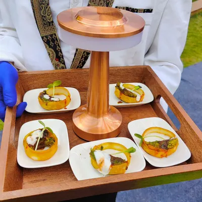 Our staff presenting potato baskets filled with savory toppings on a custom wooden tray with a built-in light. This is an example of our innovative pass-around service.