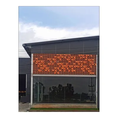 The terracotta jali facade at the Om Marble project combines a traditional material with a contemporary, randomized pattern. This creates a unique identity for the building while providing practical benefits like shading and ventilation.
