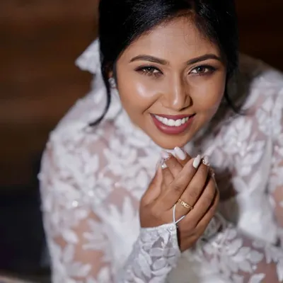 A beautiful close up of a smiling Christian bride. Her makeup is natural and radiant, with a soft lip color and defined eyes, complementing her lace gown.