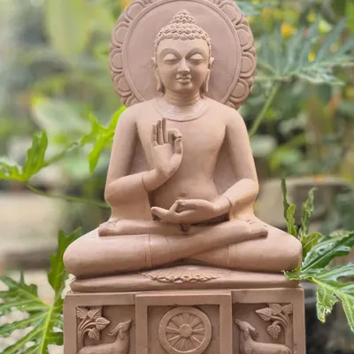 A serene Gautama Buddha statue in the dharmachakra mudra, or teaching posture. Hand-carved from pink sandstone, this piece embodies peace and is perfect for creating a tranquil meditation corner.