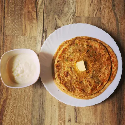 A classic Punjabi breakfast of Aloo Paratha. These fluffy flatbreads are stuffed with spiced potatoes, cooked until golden, and served with a dollop of butter and a side of cool dahi.