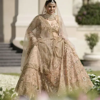 A full view of this timeless bridal look. The flowing lehenga and soft, elegant makeup come together to create a vision of understated grace, perfect for the modern bride.