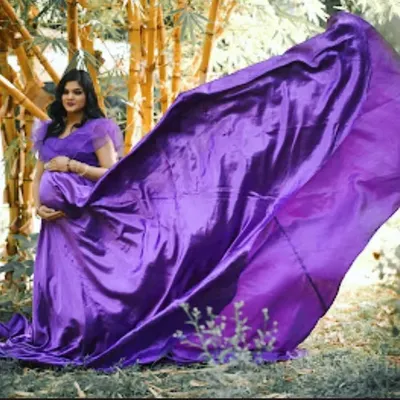 Unleash the drama with this magnificent purple trail gown. The satin fabric catches the light beautifully as it flows in the wind, creating a powerful and unforgettable image for your outdoor maternity shoot.
