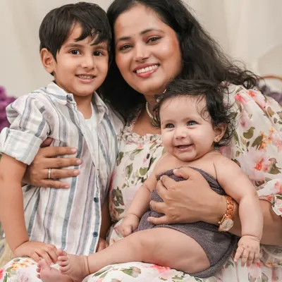 The pure joy of motherhood. This candid portrait captures a mother's love for her two children, a beautiful moment of connection and happiness.