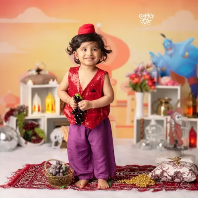Experience the enchantment of Aladdin's world. This little one, dressed in a sequined vest and fez, is ready for a magical adventure.