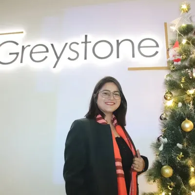 A guest posing by the company logo and Christmas tree at an office holiday party. I capture the festive branding and decor of your corporate event.
