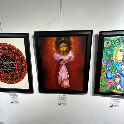 "The Worshipper of Durga" painting displayed at an exhibition, alongside other spiritual artworks.