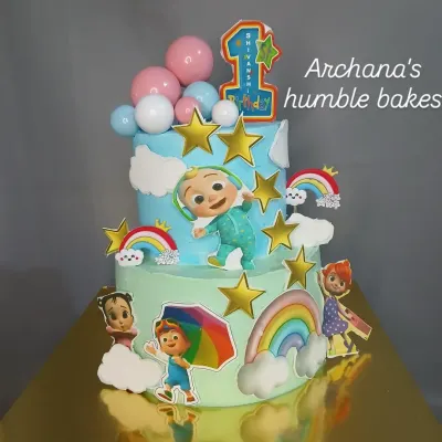 A colorful two-tier Cocomelon cake, perfect for a first birthday celebration. This design features all the beloved characters, rainbows, and stars.