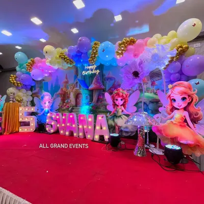 Welcome to Svana's Fairyland. This magical 5th birthday stage features a castle backdrop, large fairy cutouts, marquee letters, and a dreamy pastel balloon cloud with gold accents.