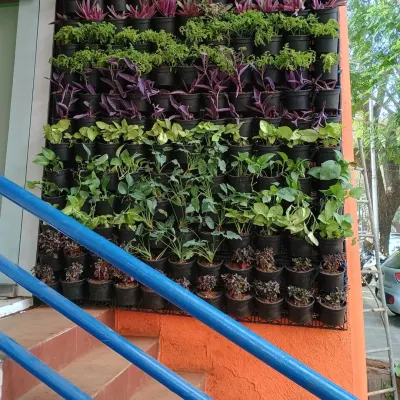 A close-up of a living wall I installed next to a staircase. You can see the individual pots seated in the grid system, filled with a mix of purple tradescantia and green foliage plants.