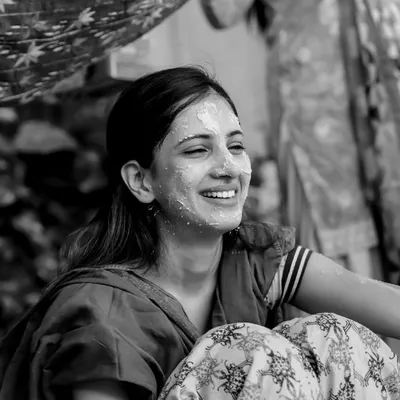 The pure joy of a Haldi ceremony captured in a timeless black and white photograph. Her radiant smile says it all, a moment of sheer happiness surrounded by loved ones.