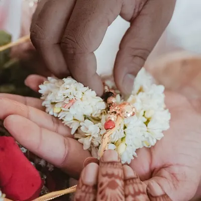 A close up on a sacred moment during the wedding ceremony. This shot focuses on the hands, the flowers, and the mangalsutra, highlighting the small but significant details.