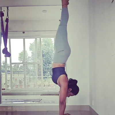 A moment of stillness, upside down. A wall-supported handstand like this is an excellent way to build the shoulder and core strength needed for freestanding inversions while getting comfortable with a new perspective.