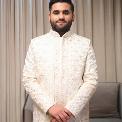 A classic portrait of a groom ready for his wedding. The makeup is kept natural to enhance his features, paired with a neatly styled beard and hair for a timeless look.