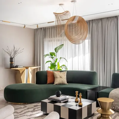 In this Santacruz duplex, we paired a deep green curved sofa with a bold checkered coffee table and sculptural brass accents. The result is a living area that feels sophisticated and cozy, with unique lighting that draws the eye and enhances the room's modern design.