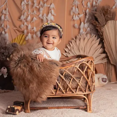 This adorable little one is all smiles in our bohemian-themed setup. The rattan bassinet, pampas grass, and feather garland create a soft, natural, and dreamy atmosphere.